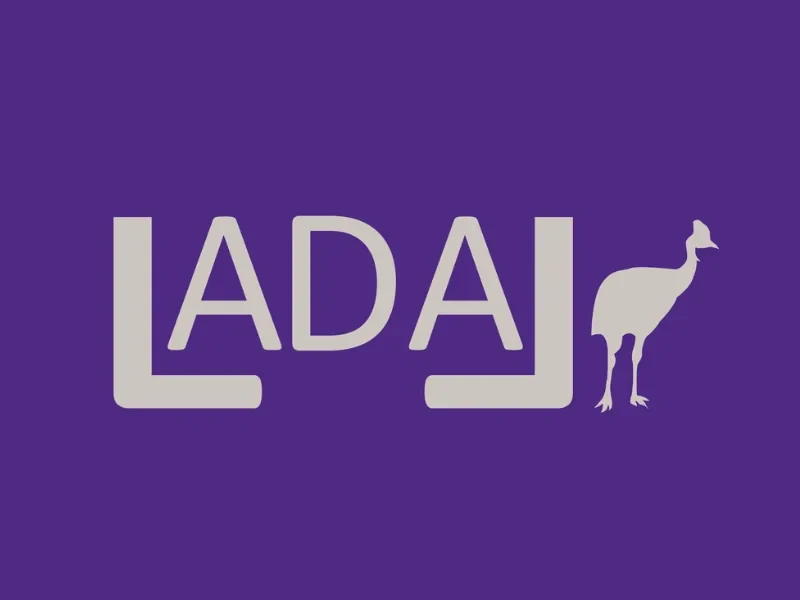 Eine Wissenschaftlerin und ein Wissenschaftler arbeiten hinter einer Glasfassade und mischen Chemikalien mit Großgeräten.