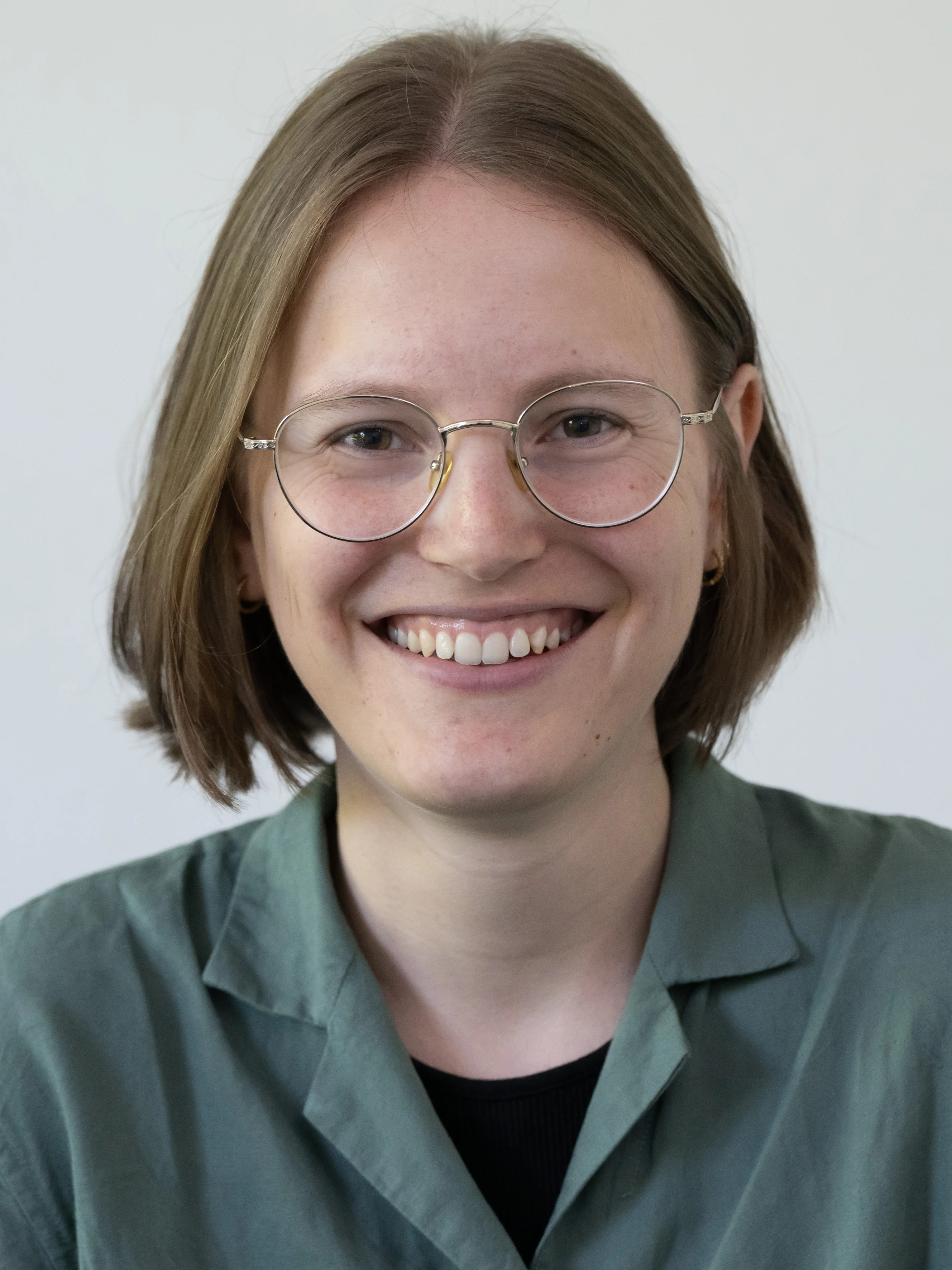 Eine Wissenschaftlerin und ein Wissenschaftler arbeiten hinter einer Glasfassade und mischen Chemikalien mit Großgeräten.